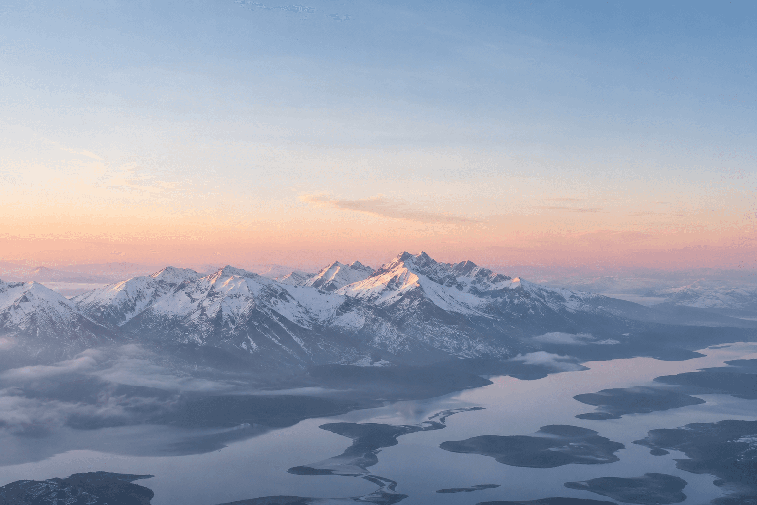 Layered mountain ridges receding into dawn mist
